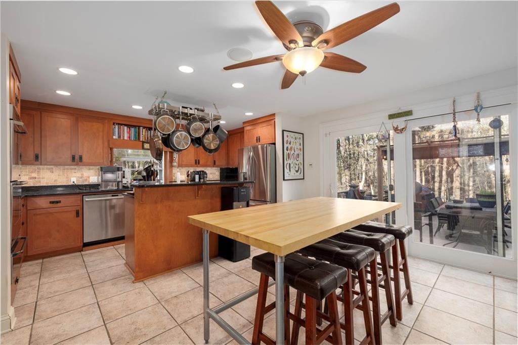 2010 Carrington Court Smoke Rise, GA 30087 - Photo 14 of 56 a kitchen with stainless steel appliances kitchen island granite countertop a table chairs and a refrigerator