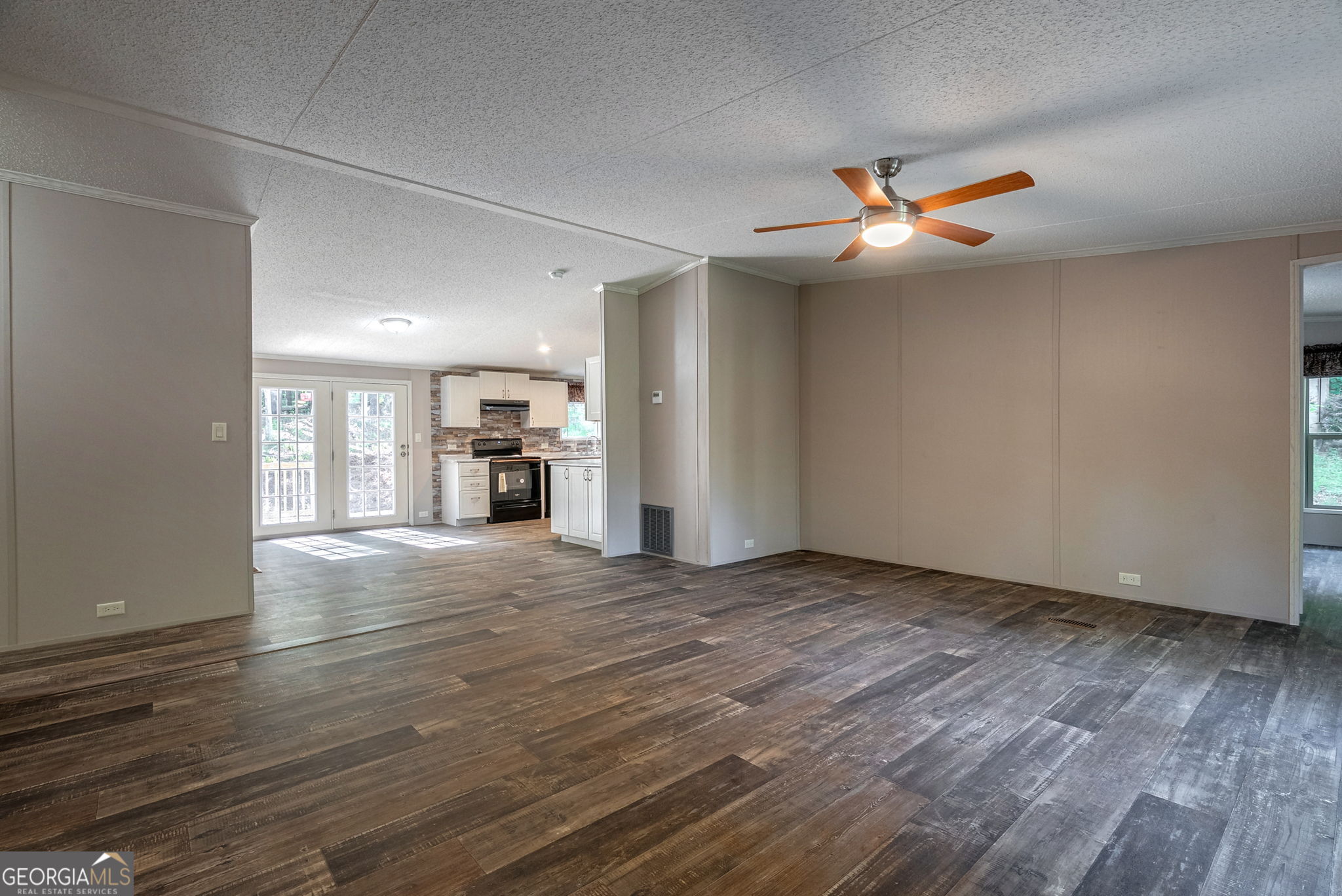 128 Sunfish Trail Southwest Eatonton, GA 31024 - Photo 6 of 48 an empty room with wooden floor fireplace and windows