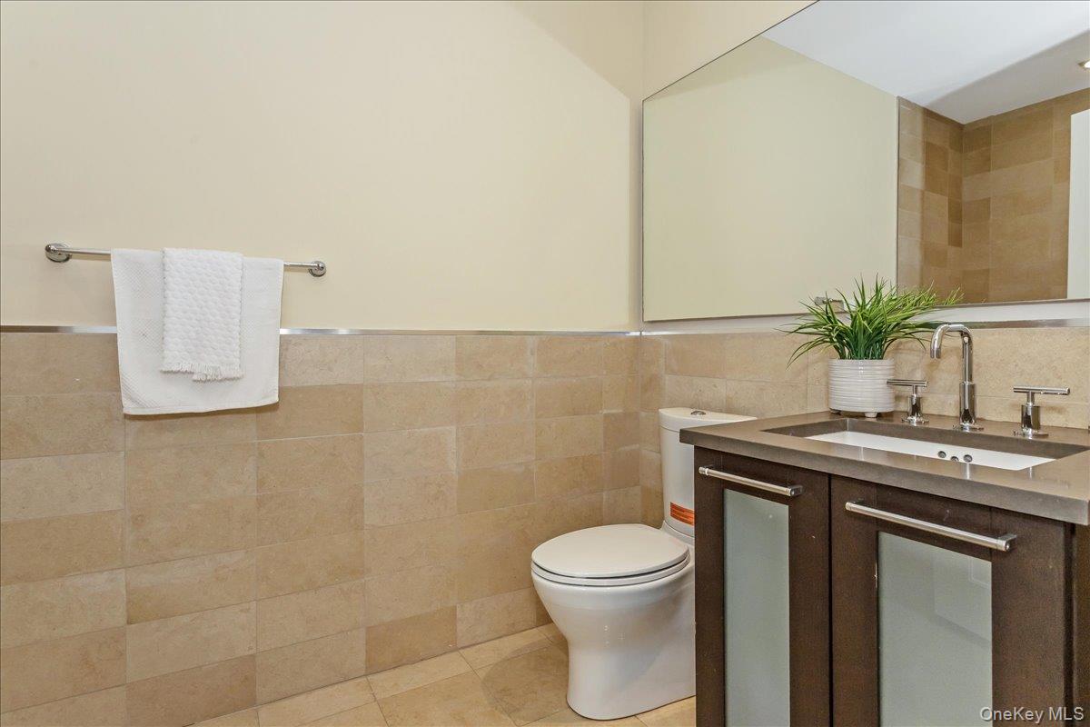 64-05 Yellowstone Boulevard, Unit 207 Queens, NY 11375 - Photo 13 of 18 a bathroom with a granite countertop sink a toilet and a mirror