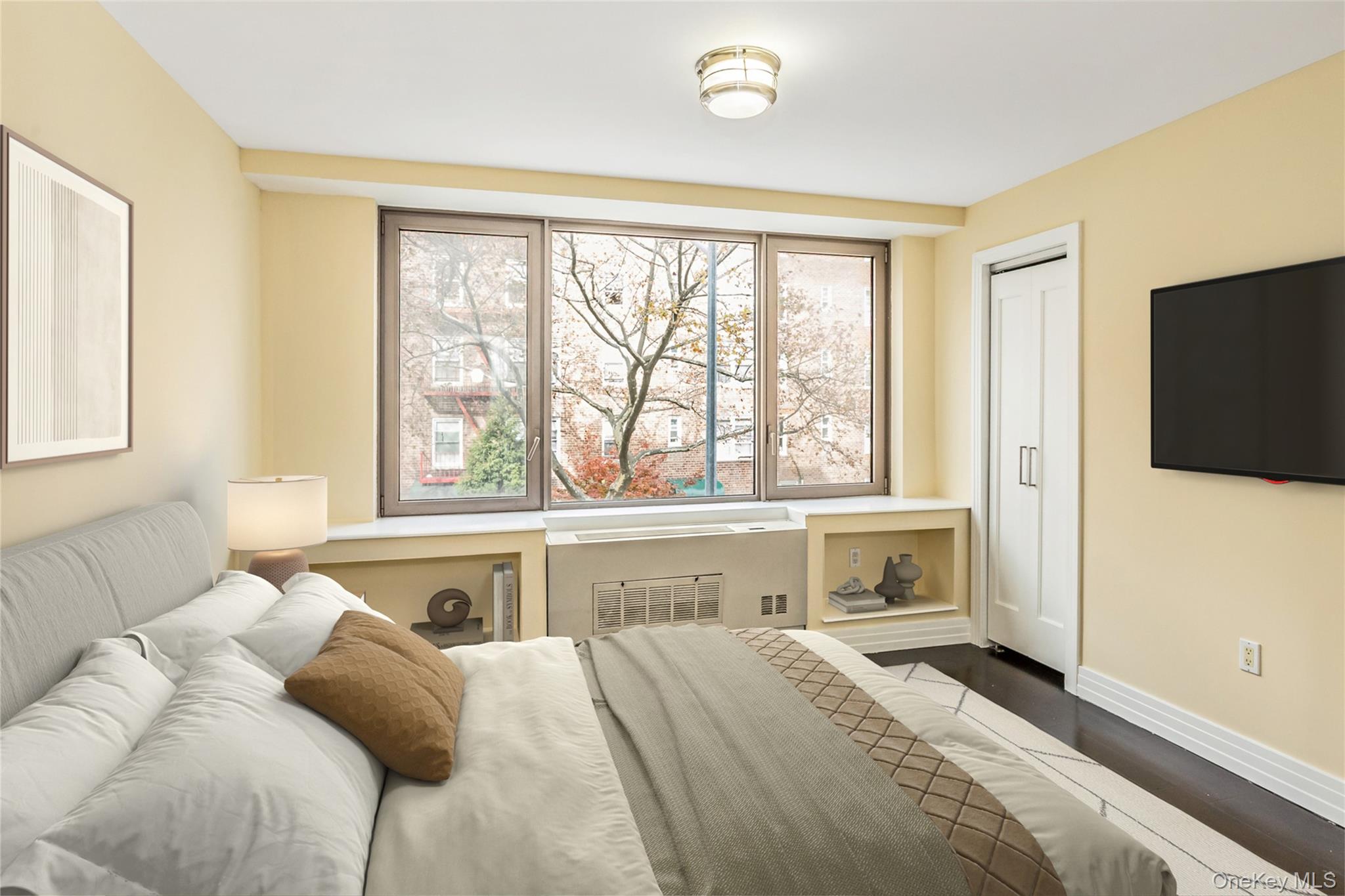 64-05 Yellowstone Boulevard, Unit 207 Queens, NY 11375 - Photo 3 of 18 a bedroom with a bed and a large window