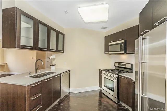 a kitchen with stainless steel appliances granite countertop a stove a sink and a microwave