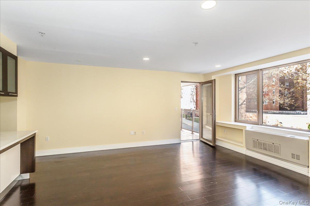 64-05 Yellowstone Boulevard, Unit 207 Queens, NY 11375 - Photo 7 of 18 a view of an empty room with a window and wooden floor