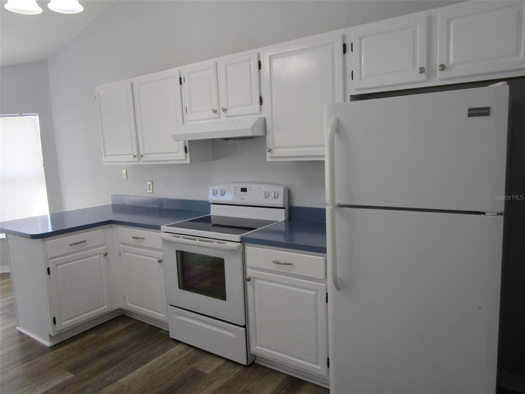 8826 Kilmer Way Hudson, FL 34667 - Photo 15 of 36 a kitchen with cabinets appliances and wooden floor