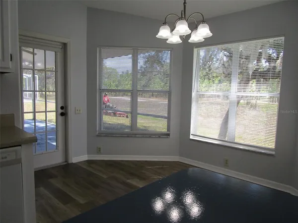 a view of an empty room with a chandelier fan and wooden floor