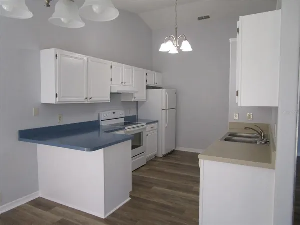 a kitchen with stainless steel appliances a stove a sink and white cabinets