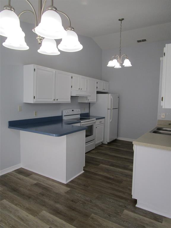 8826 Kilmer Way Hudson, FL 34667 - Photo 18 of 36 a kitchen with stainless steel appliances granite countertop a sink a stove and white cabinets with wooden floor