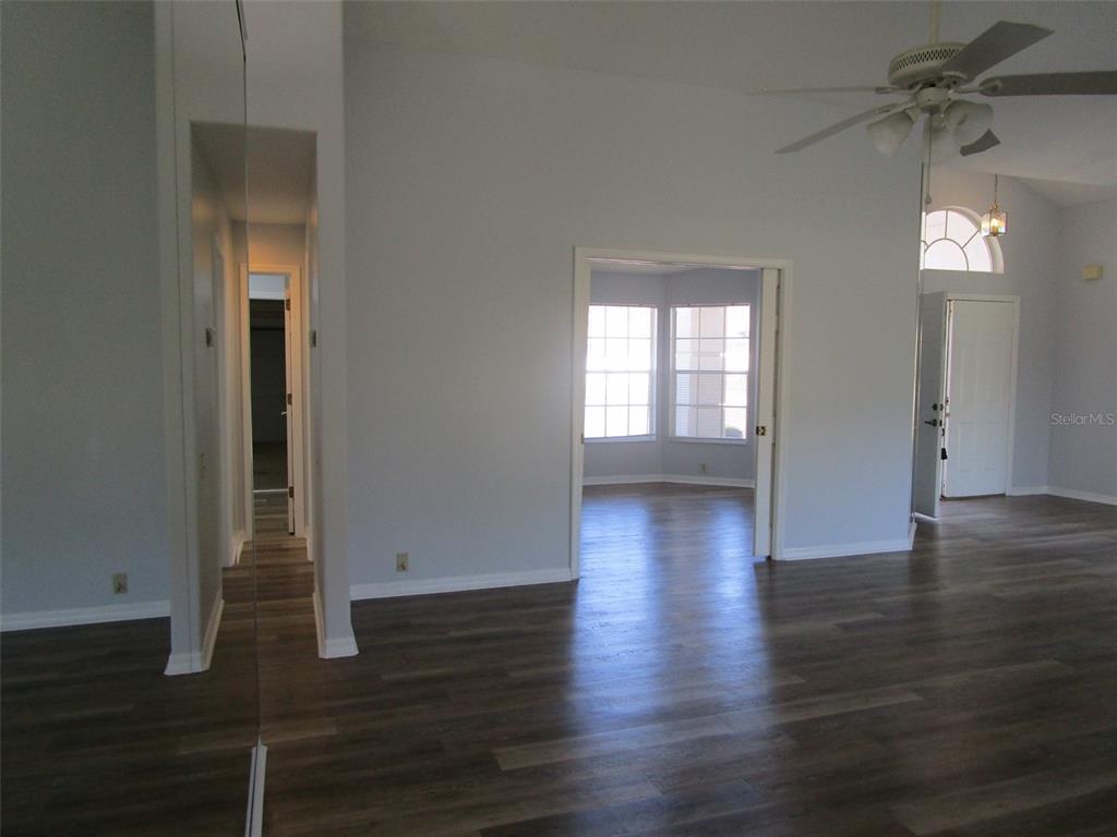 8826 Kilmer Way Hudson, FL 34667 - Photo 19 of 36 an empty room with wooden floor and windows