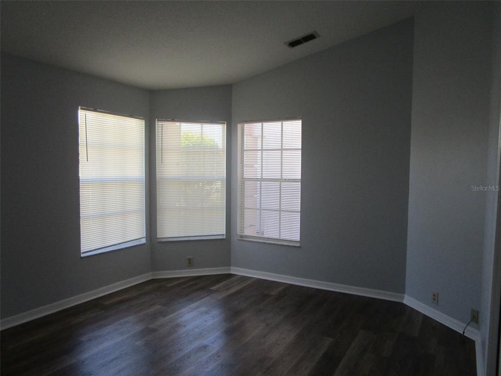 8826 Kilmer Way Hudson, FL 34667 - Photo 20 of 36 an empty room with wooden floor and windows