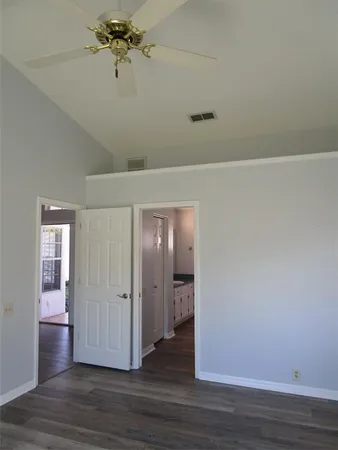 a view of a hallway with wooden floor and chandelier