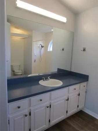 a bathroom with a granite countertop sink and white cabinets