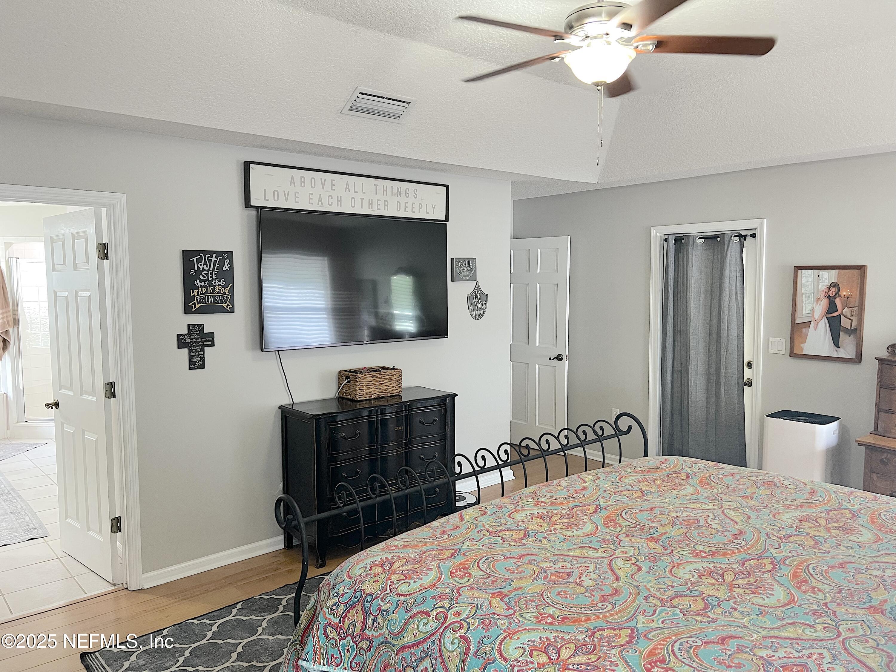 2020 Belle Grove Trace Fleming Island, FL 32003 - Photo 16 of 31 a bedroom with a bed and a chandelier