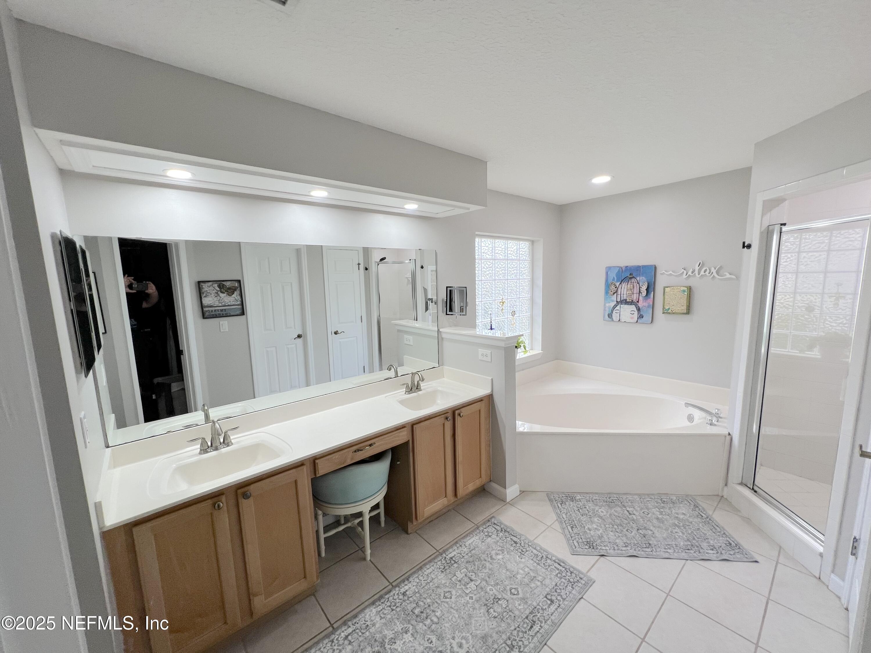 2020 Belle Grove Trace Fleming Island, FL 32003 - Photo 25 of 31 a bathroom with a tub a sink and a mirror