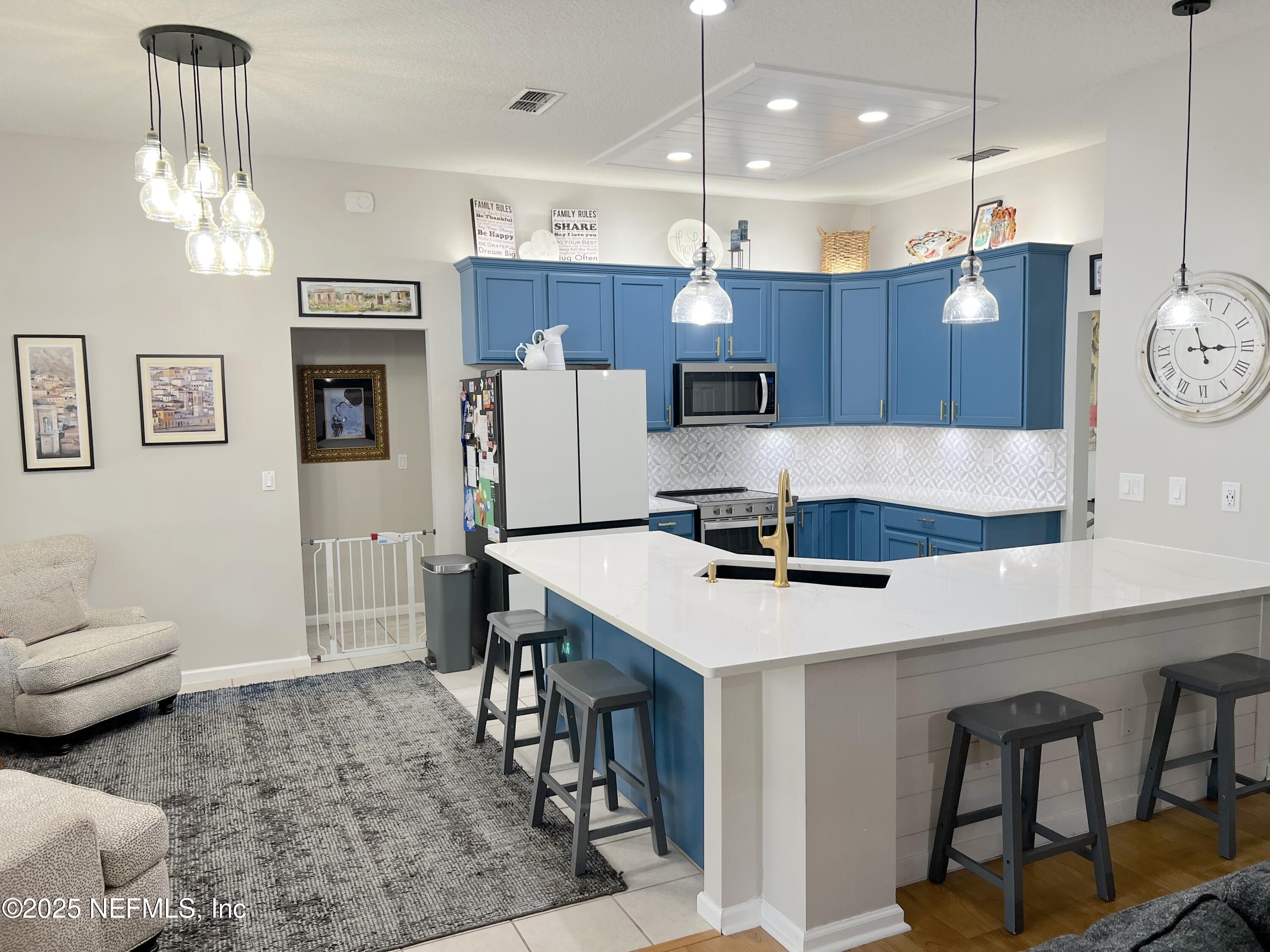 2020 Belle Grove Trace Fleming Island, FL 32003 - Photo 6 of 31 a kitchen with a refrigerator a stove and chairs