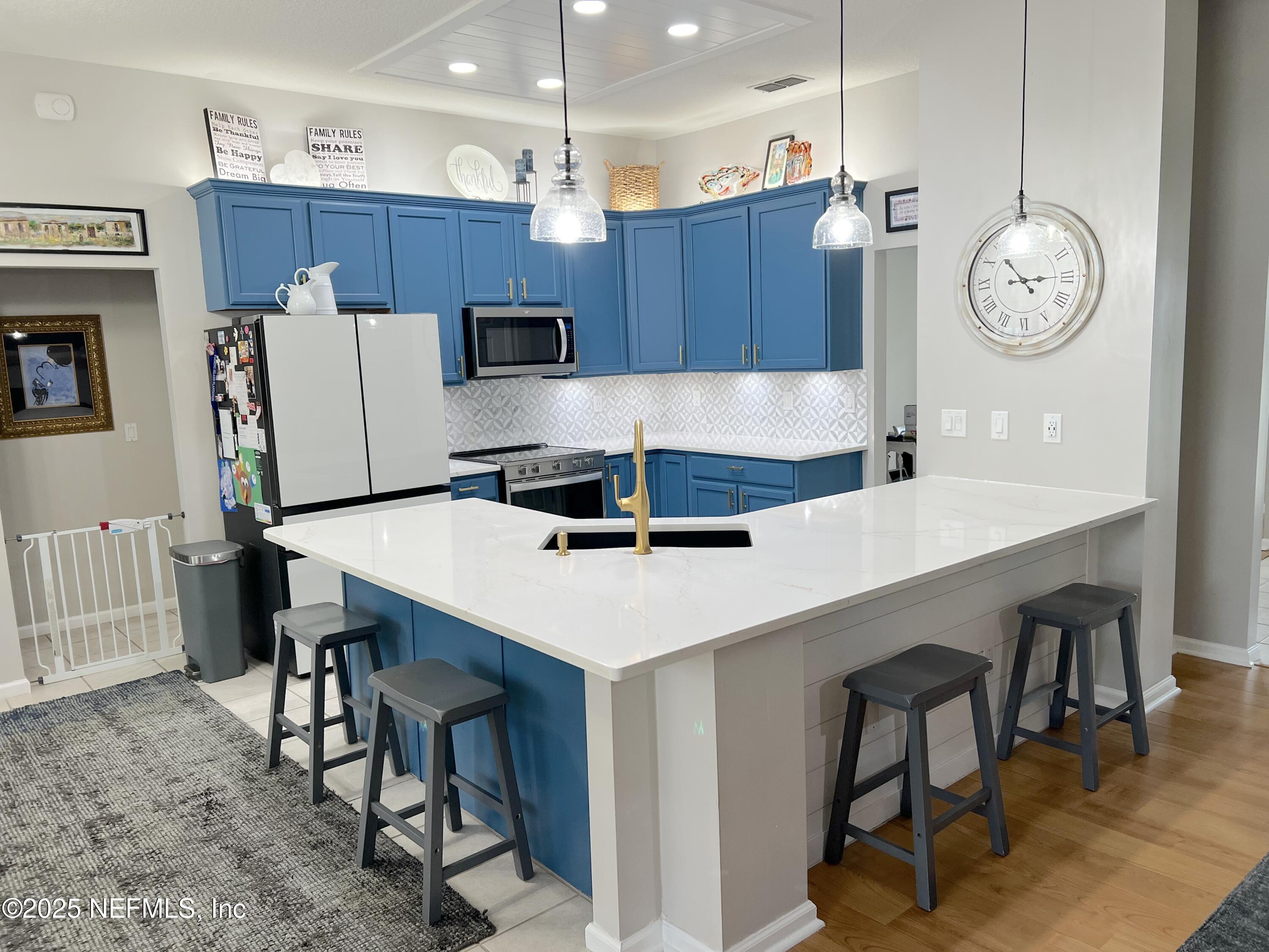 2020 Belle Grove Trace Fleming Island, FL 32003 - Photo 7 of 31 a kitchen with kitchen island a dining table and chairs