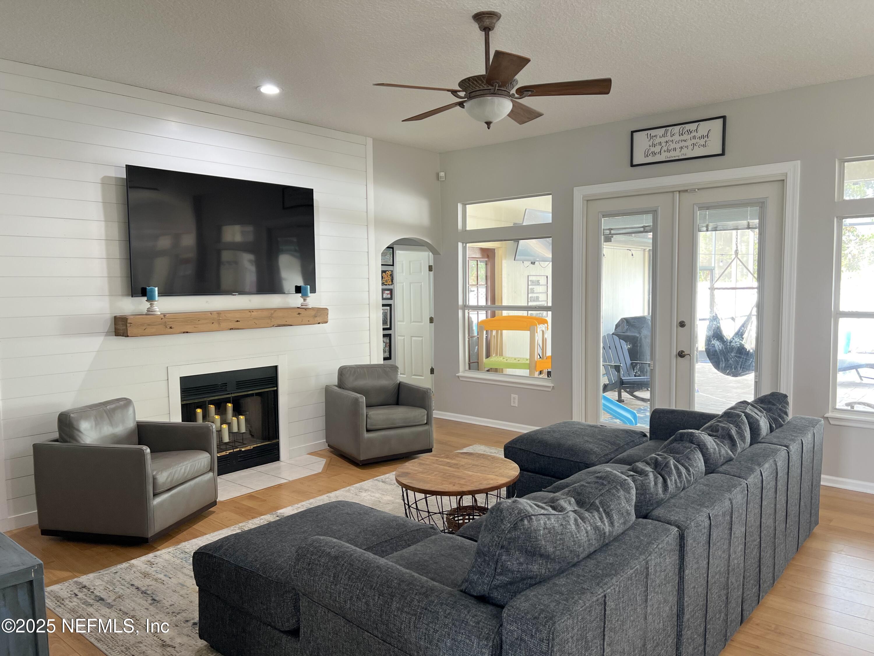 2020 Belle Grove Trace Fleming Island, FL 32003 - Photo 10 of 31 a living room with furniture a fireplace and a flat screen tv