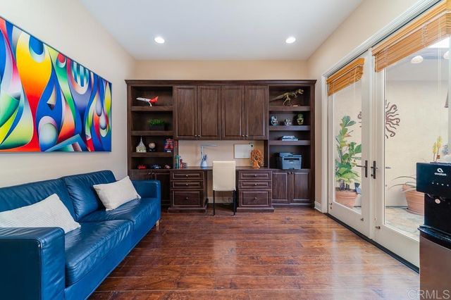 a view of a dining room with furniture a chandelier and wooden floor