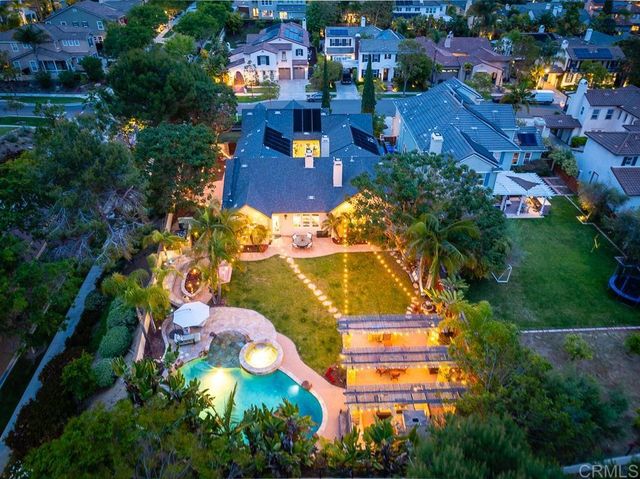 a view of a patio with couches table and chairs under an umbrella