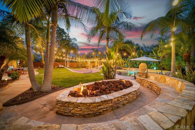 a living room with patio furniture and a potted plant