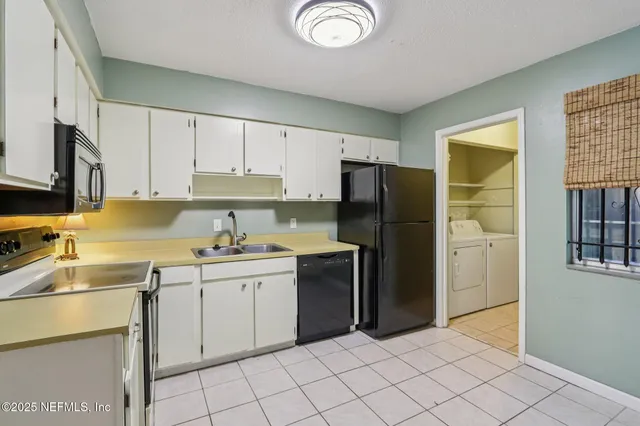 a kitchen with a sink a refrigerator and cabinets