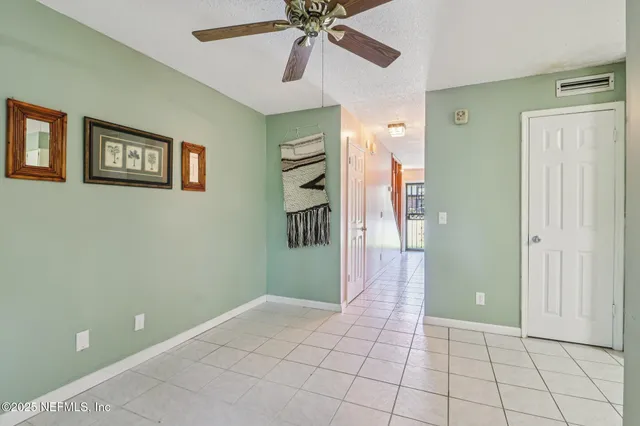 a view of an empty room with window and a livingroom