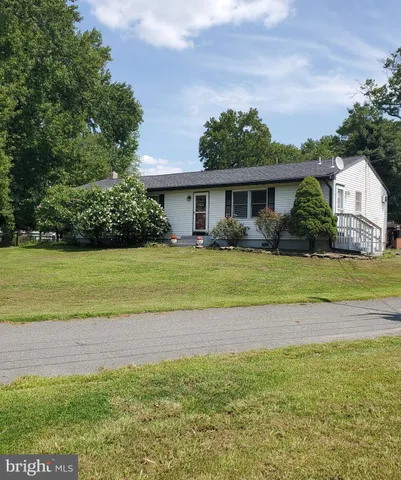 a view of a house with a yard and potted plants