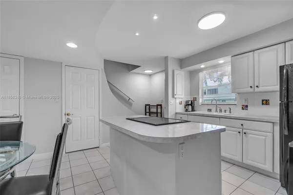 a kitchen with a dining table chairs and refrigerator