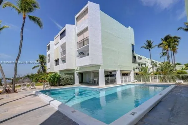 a view of a swimming pool with a yard and plants