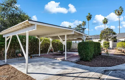a view of a patio with table and chairs potted plants with wooden floor and fence