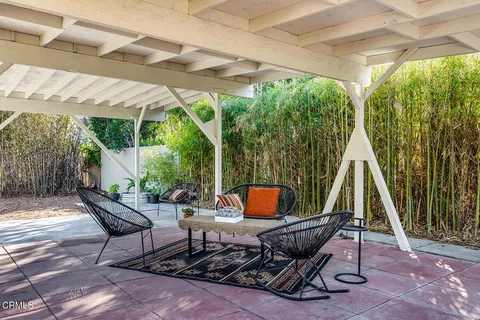 a view of backyard with table and chairs and wooden fence