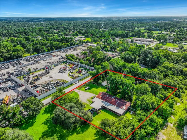 an aerial view of residential houses with outdoor space and trees