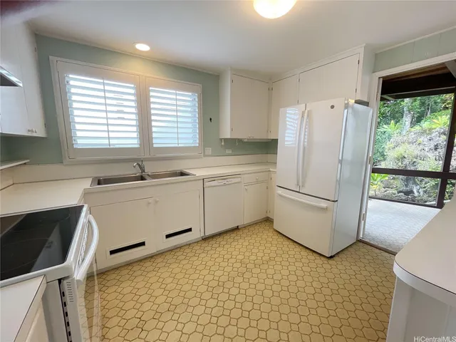 a view of an empty room with wooden floor and windows