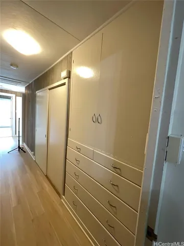 a view of an empty room with wooden floor and a ceiling fan