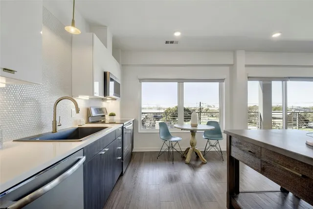 a view of a kitchen with kitchen island wooden floors and living room