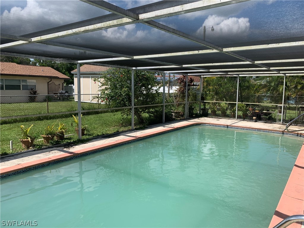 119 Rowland Road Lehigh Acres, FL 33936 - Photo 3 of 20 a swimming pool with glass windows and garden view
