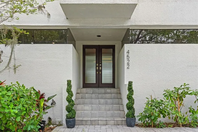 a front view of a house with plants