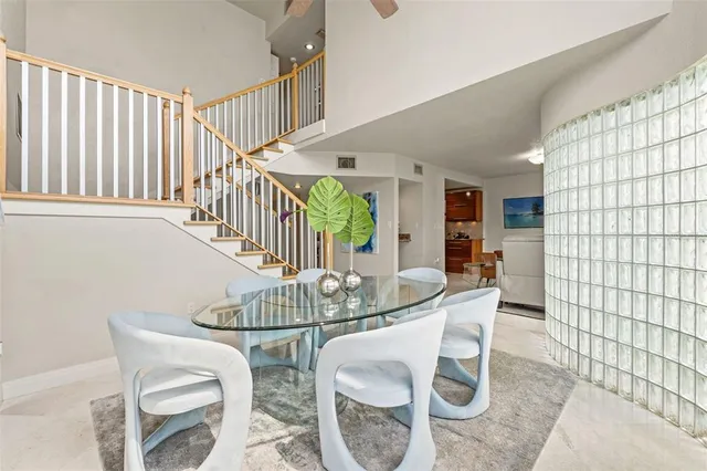 a vase of flowers sitting on a table with chairs