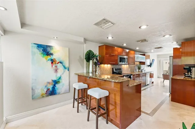 a kitchen with stainless steel appliances granite countertop a refrigerator and a sink