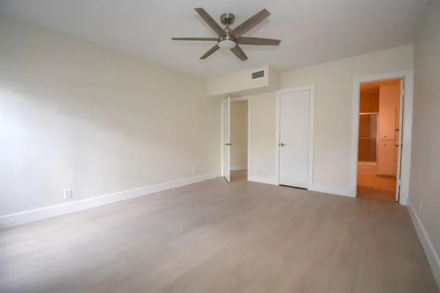 an empty room with a ceiling fan and a window
