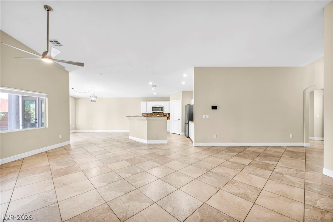 6405 North Raptor Court North Las Vegas, NV 89084 - Photo 26 of 66 An open-concept living space with sleek tile flooring extends towards a modern kitchen.