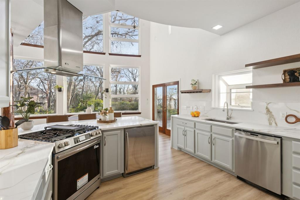 540 Diamond Point Drive Oak Point, TX 75068 - Photo 9 of 27 Kitchen featuring open shelves, appliances with stainless steel finishes, light stone counters, island exhaust hood, and lofted ceiling