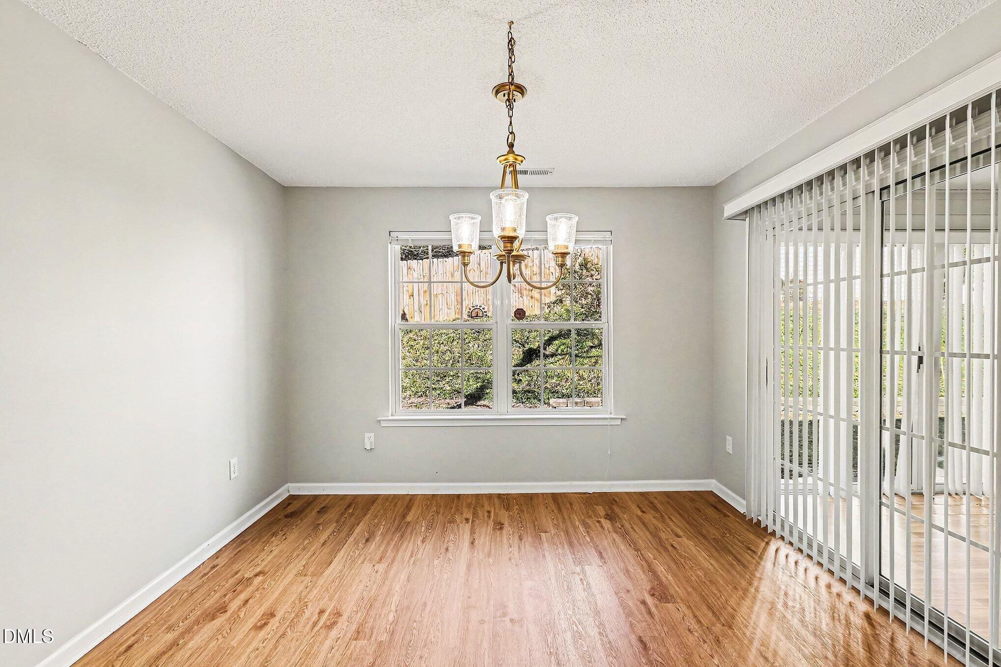 5017 Tapestry Terrace Durham, NC 27713 - Photo 11 of 28 a view of a room with wooden floor chandelier and windows