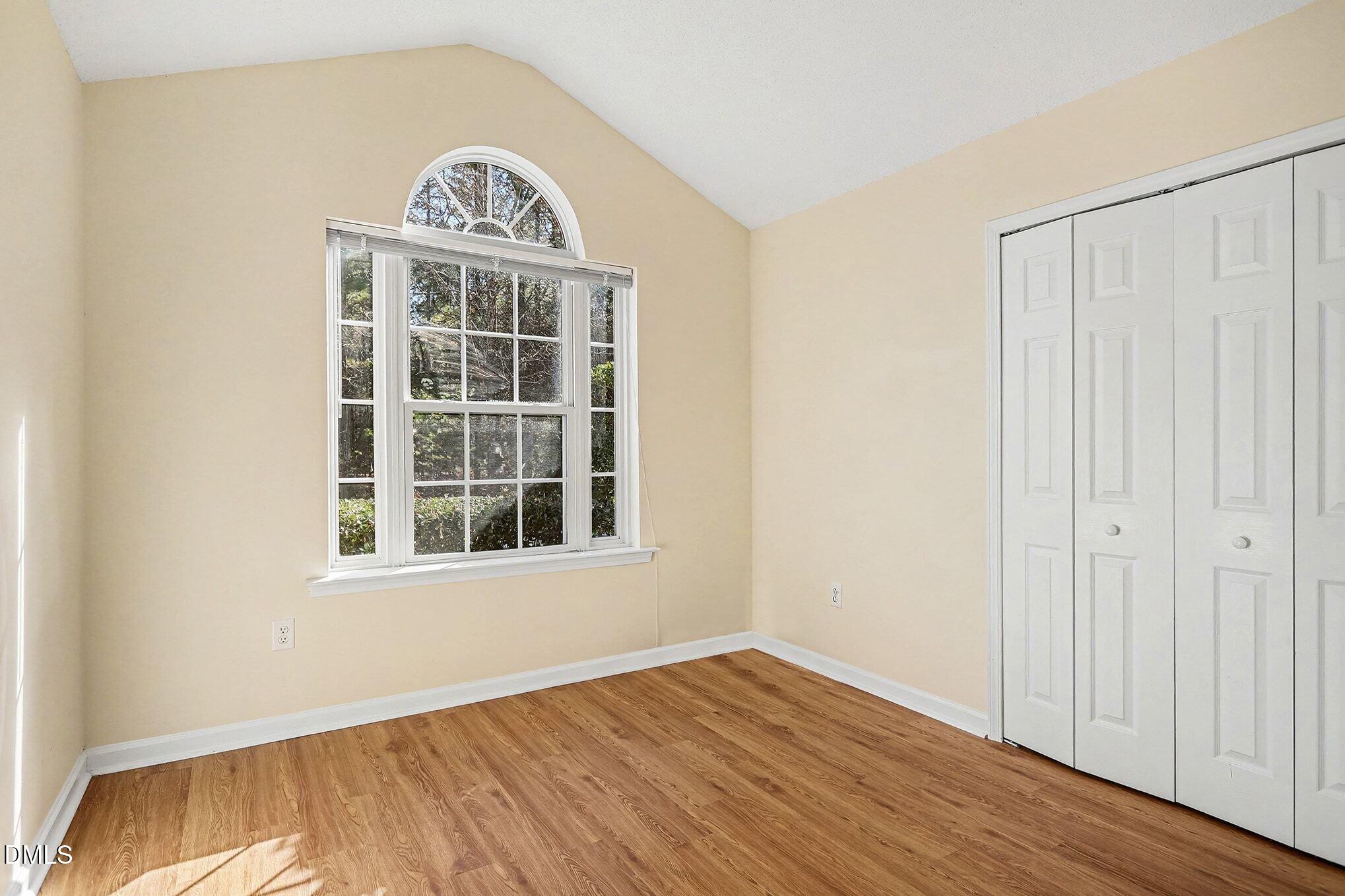 5017 Tapestry Terrace Durham, NC 27713 - Photo 18 of 28 a view of an empty room with wooden floor and a window