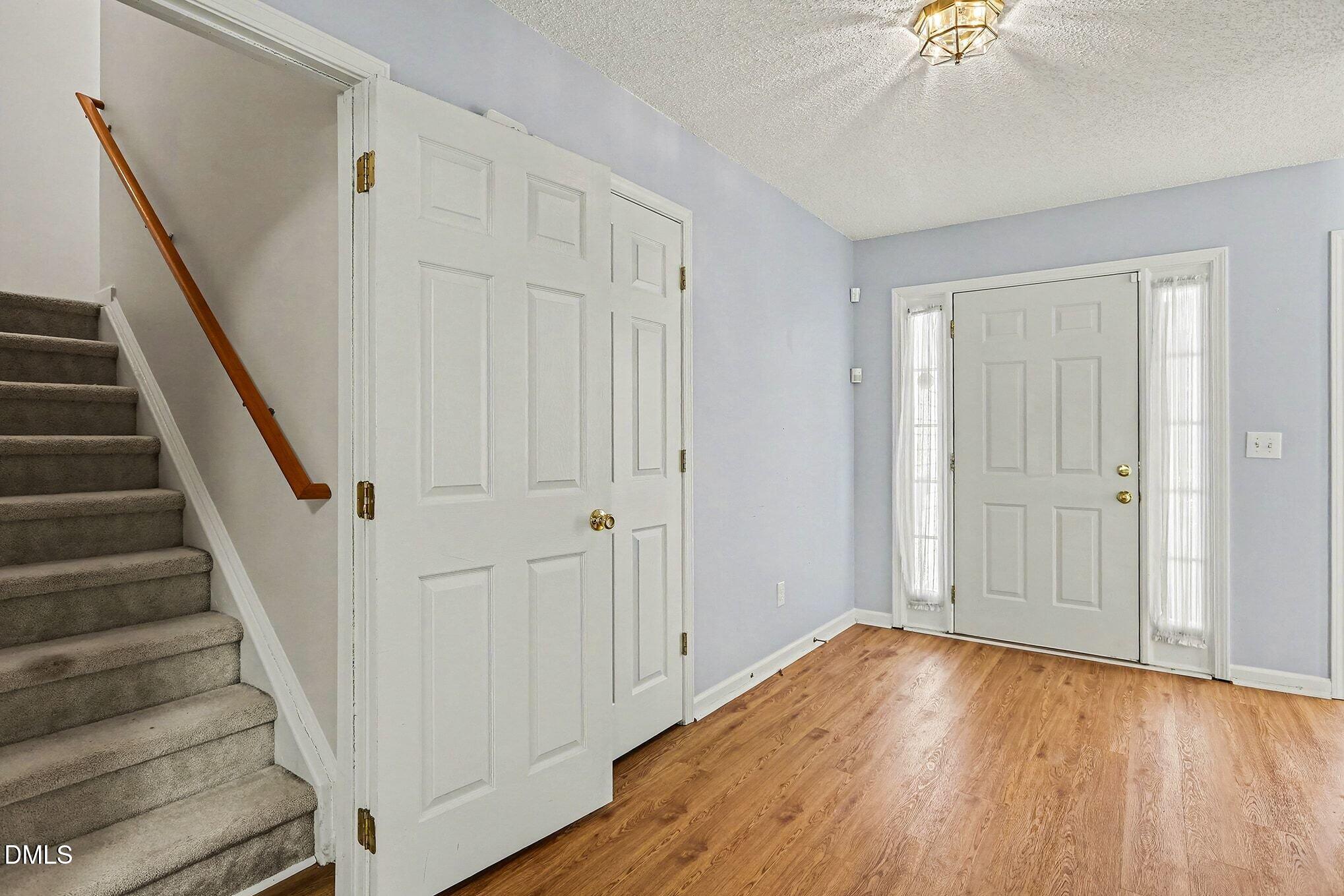 5017 Tapestry Terrace Durham, NC 27713 - Photo 3 of 28 a view of a hallway with wooden floor and staircase