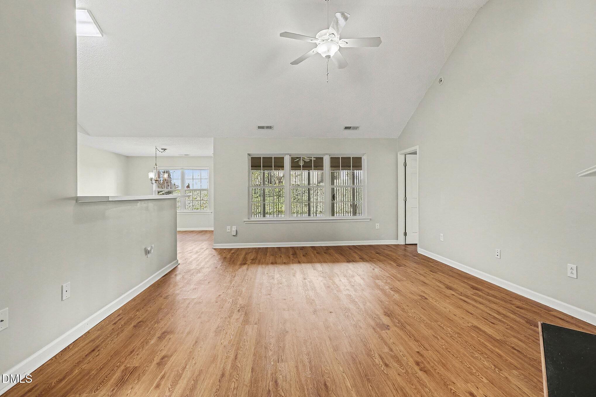 5017 Tapestry Terrace Durham, NC 27713 - Photo 7 of 28 an empty room with wooden floor fan and windows