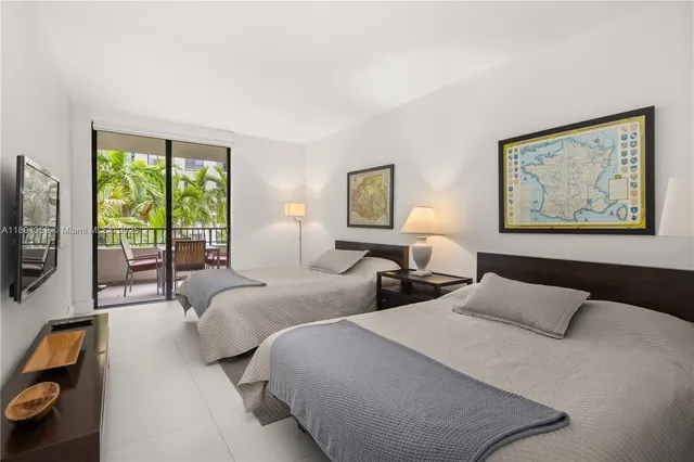 a bedroom with two beds and a flat screen tv