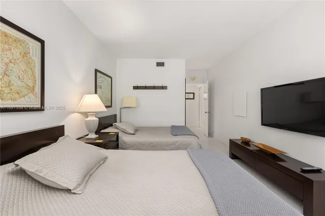 a bedroom with a bed and flat screen tv