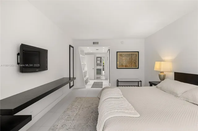 a bedroom with a large bed and a flat screen tv