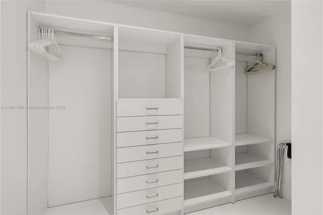a view of walk in closet with empty racks