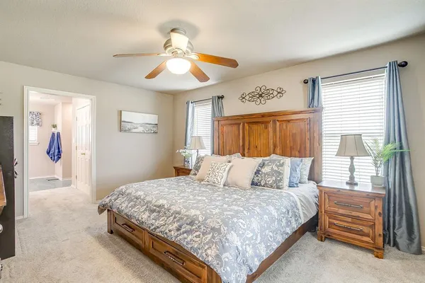 a bedroom with a large bed and a chandelier