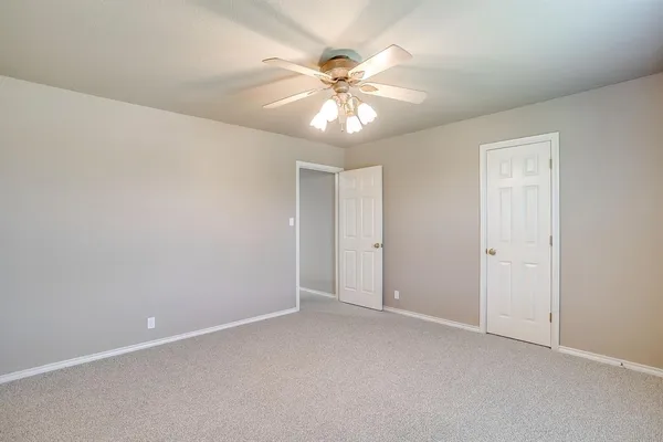 an empty room with a window and a fan